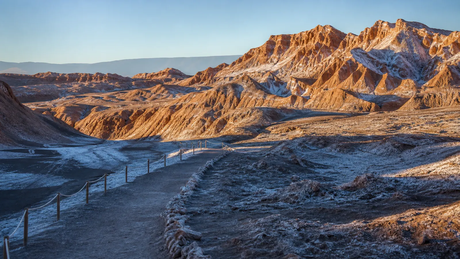 Luz fría de una mañana de invierno sobre relieves de sal y arcilla y un sendero marcado en el Valle de la Luna